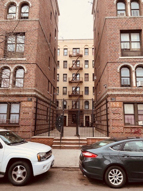 two cars parked in front of two brick buildings