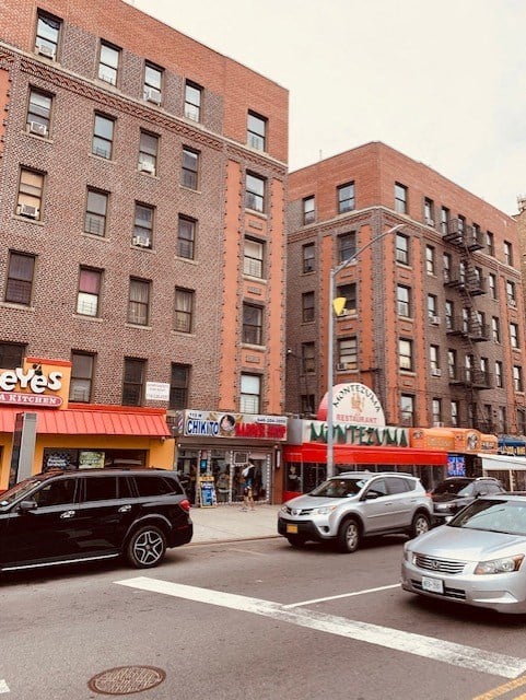 a busy city street with cars and tall brick buildings