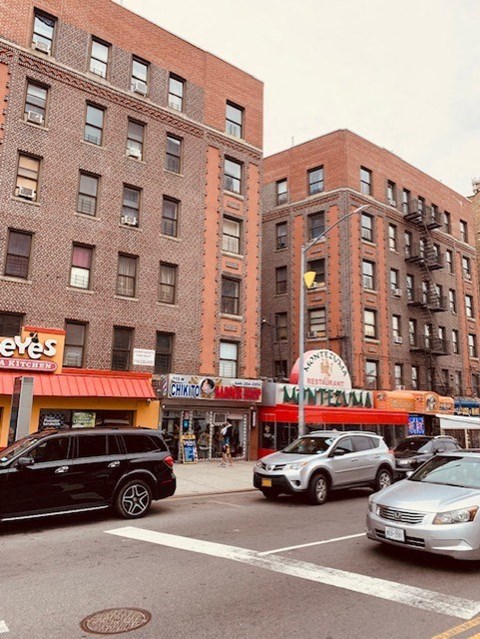 a busy city street with cars and tall brick buildings