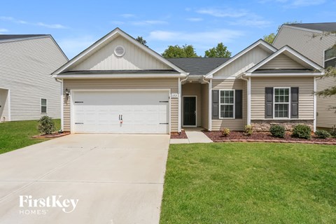 A house with a garage and a driveway in front of it.