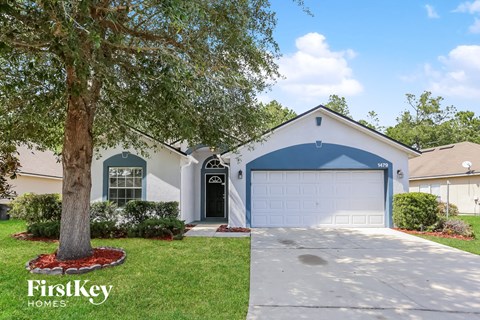 a white house with a tree in front of it