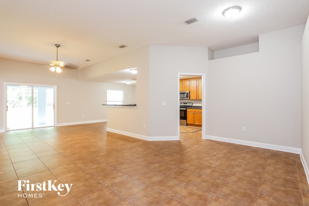 the living room and kitchen of an empty house