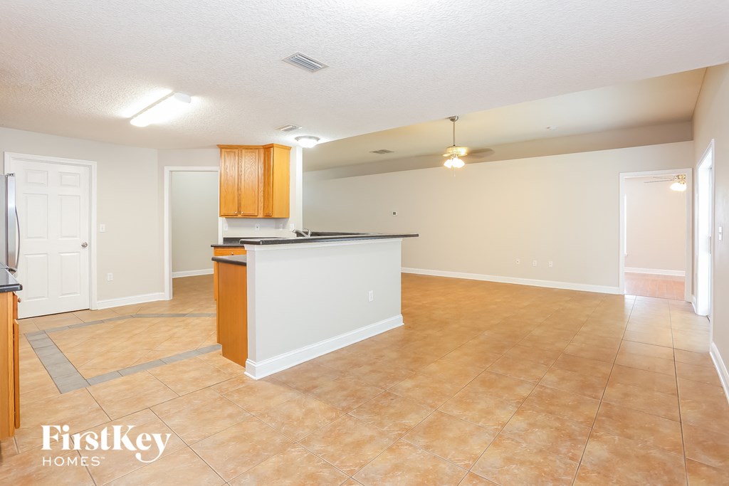 an empty kitchen and living room with a counter top