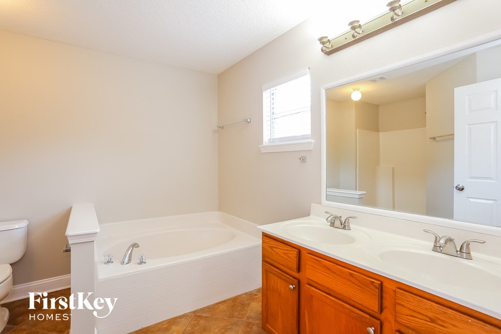 a bathroom with two sinks and a tub and a mirror