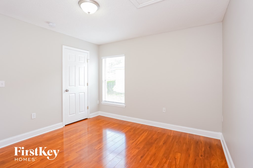 a living room with wood floors and a white door