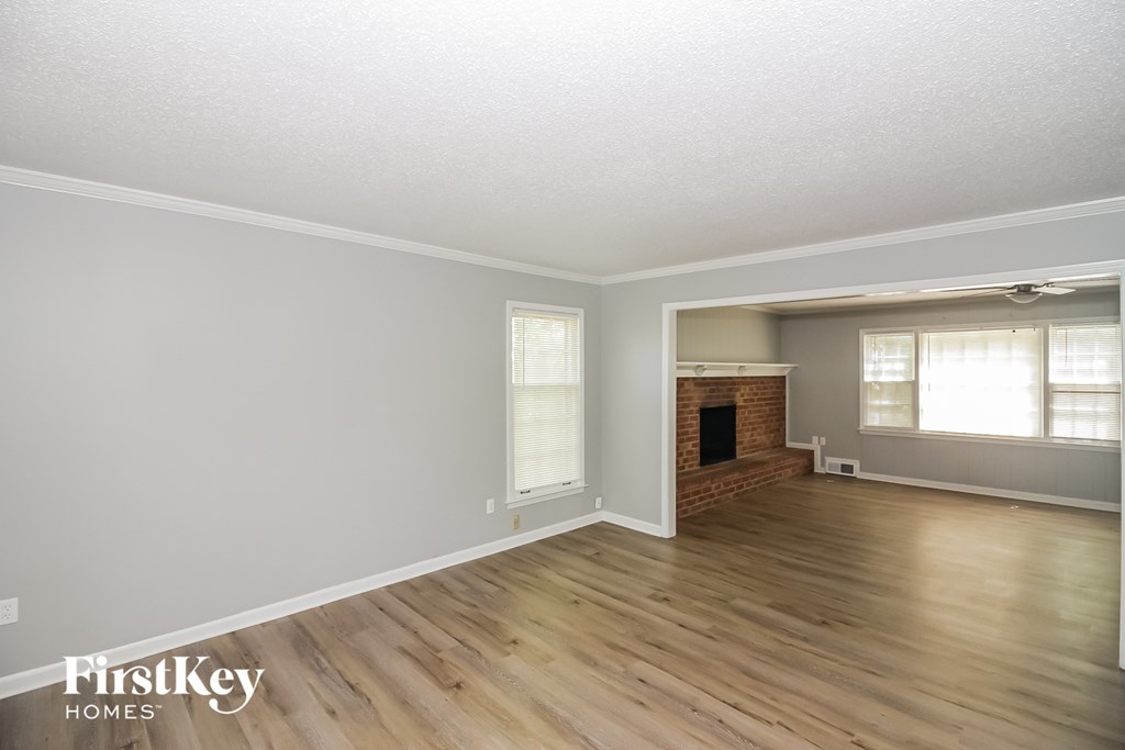 A room with wooden floors and a brick fireplace.