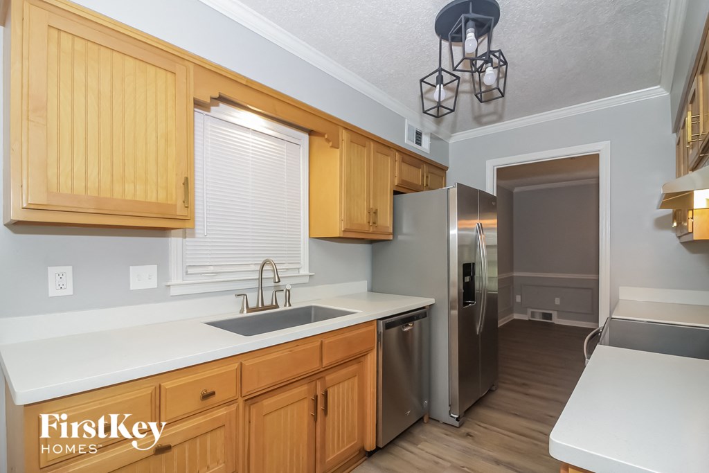 A kitchen with wooden cabinets and a stainless steel refrigerator.