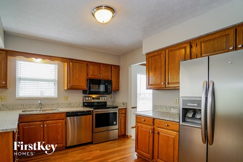 A kitchen with wooden cabinets and a stainless steel refrigerator.