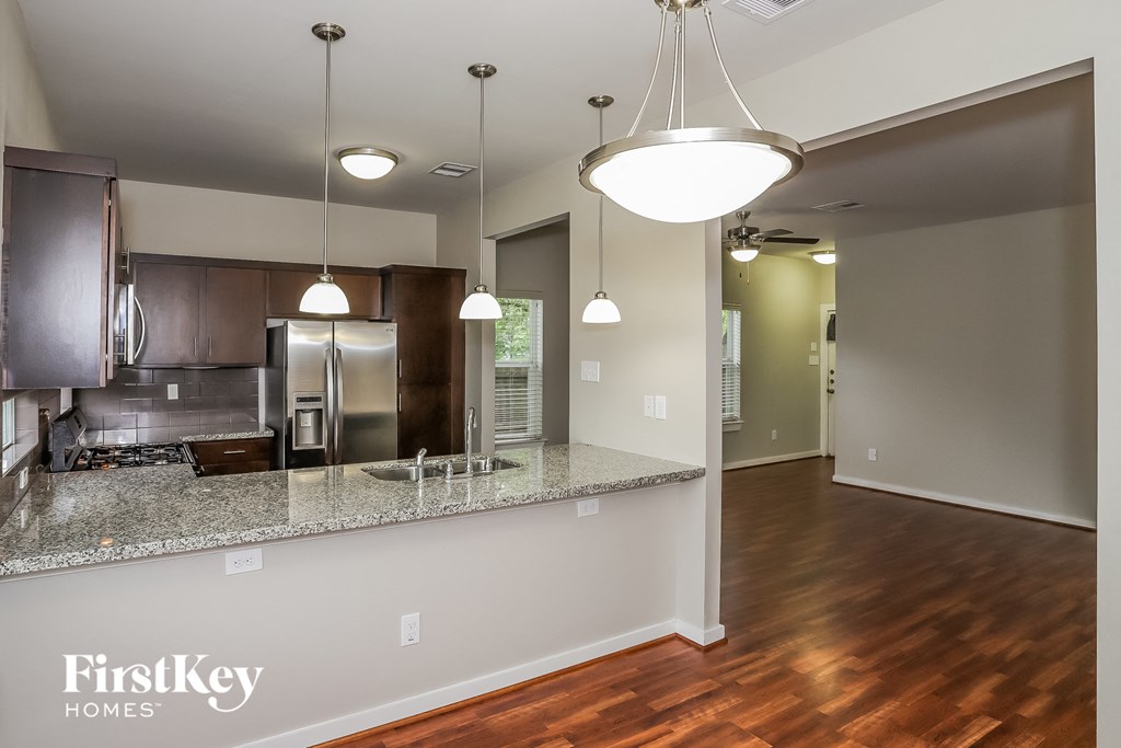 A kitchen with a granite countertop and a FirstKey Homes logo.