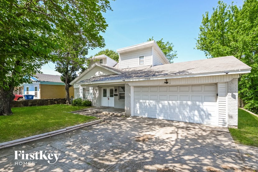 a white house with a driveway and a white garage door