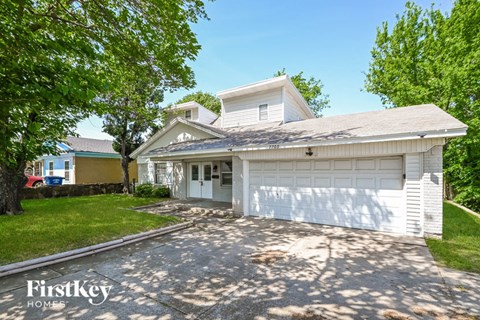 a white house with a driveway and a white garage door