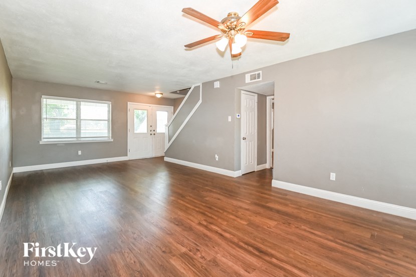 the living room of an empty house with a ceiling fan