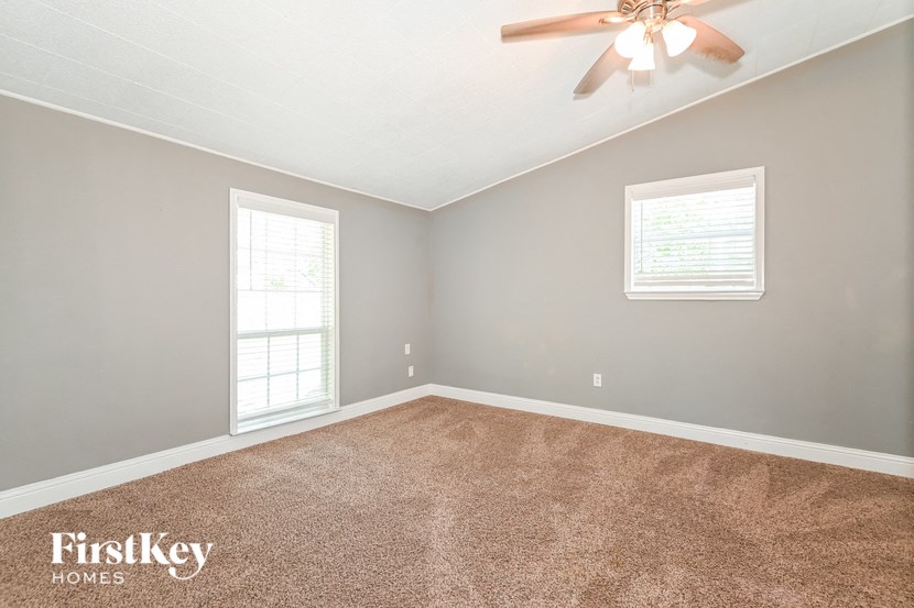 an empty room with a ceiling fan and a window