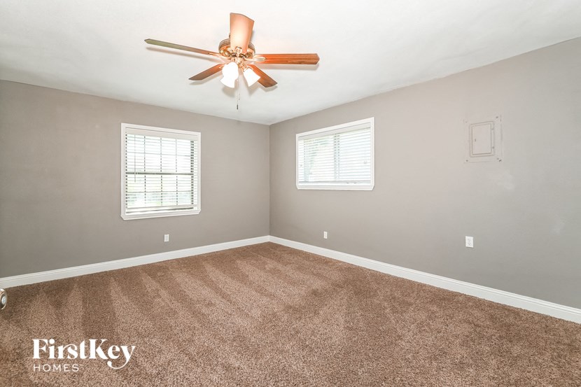 an empty living room with a ceiling fan