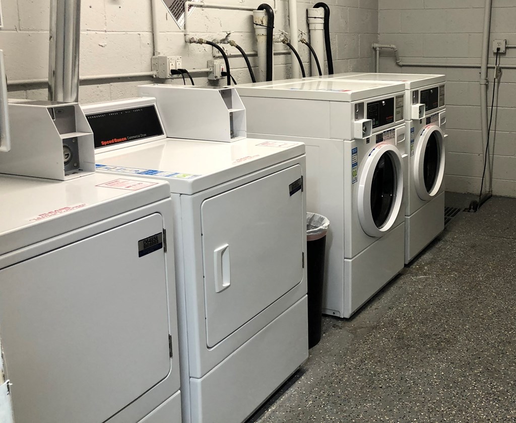 a row of washers and washing machines in a laundromat
