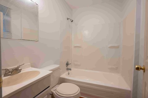 A bathroom with a toilet, sink, and bathtub.