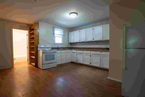 A kitchen with white cabinets and a stove top oven.