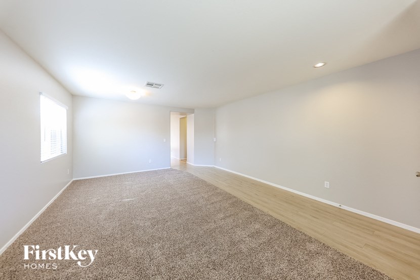 an empty living room with white walls and wood floors