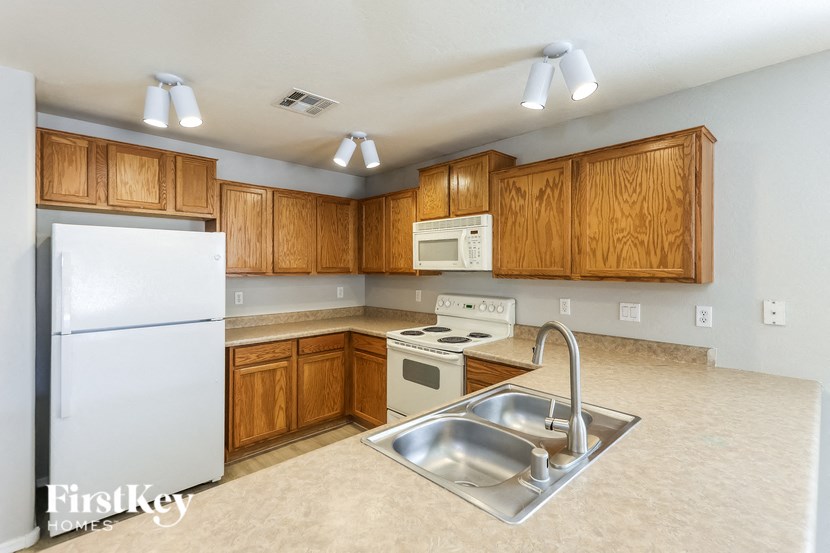 a kitchen with white appliances and wooden cabinets