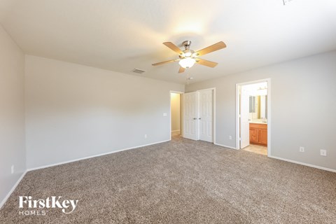 a living room with carpet and a ceiling fan