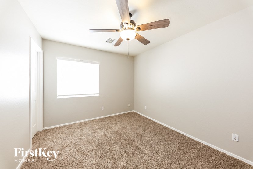 a bedroom with a ceiling fan and a window