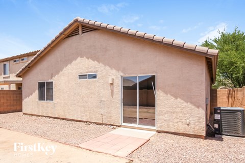 A house with a brown stucco exterior and a tiled roof.