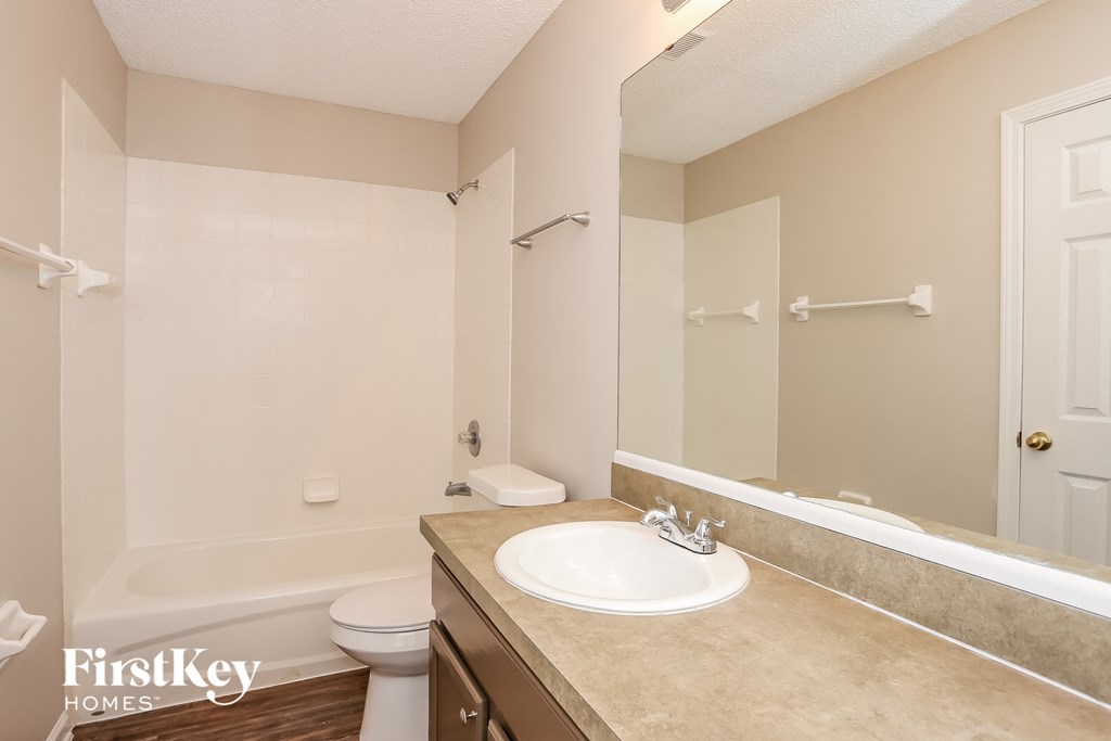 A bathroom with a sink, toilet, and bathtub.