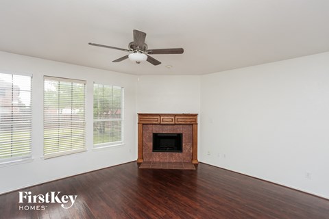 a living room with a fireplace and a ceiling fan