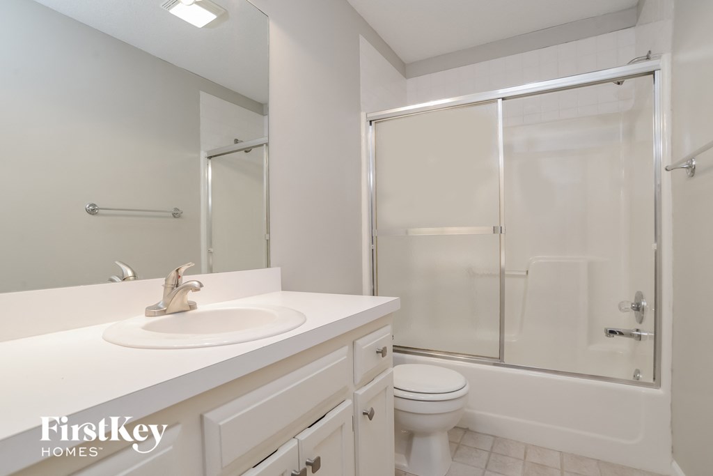 a bathroom with a sink and a shower and a toilet