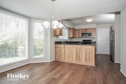 A kitchen with wooden cabinets and a black countertop.