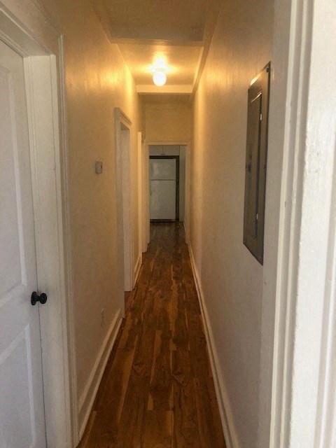 a hallway with a wood floor and a white door