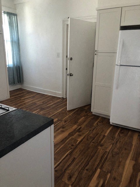 a kitchen with white cabinets and a refrigerator