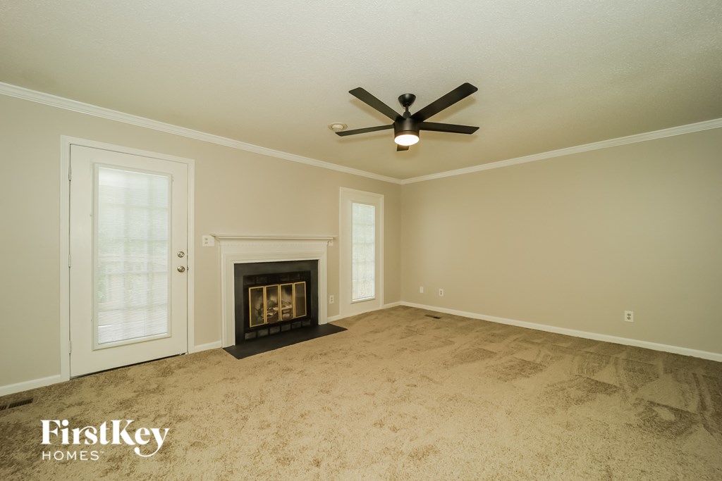 A room with a fireplace and a ceiling fan.