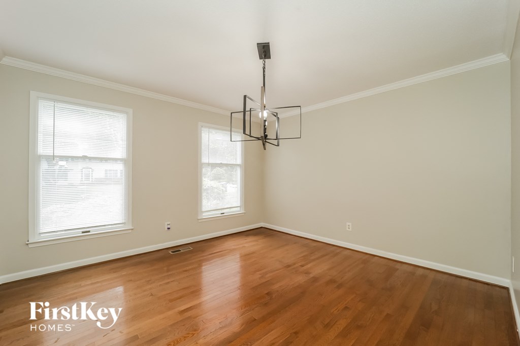 A room with wooden floors and a chandelier hanging from the ceiling.