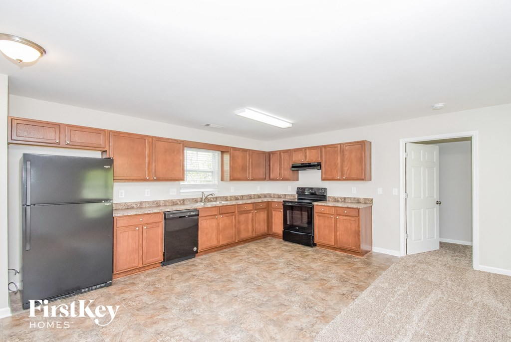 a kitchen with wooden cabinets and a black refrigerator