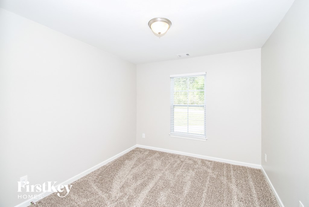 a empty room with carpet and a window