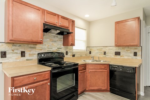 a kitchen with wood cabinets and black appliances and a stove top oven