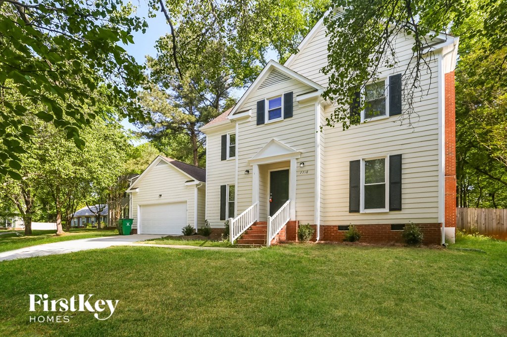 A white house with a red brick chimney is for sale.