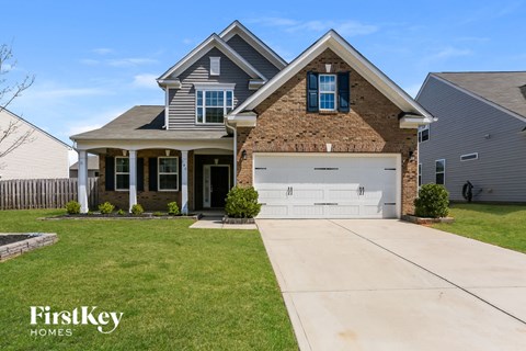 a house with a white garage door in front of a lawn