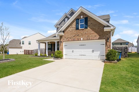 a brick house with a white garage door in front of a lawn