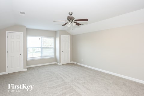 a bedroom with white carpet and a ceiling fan
