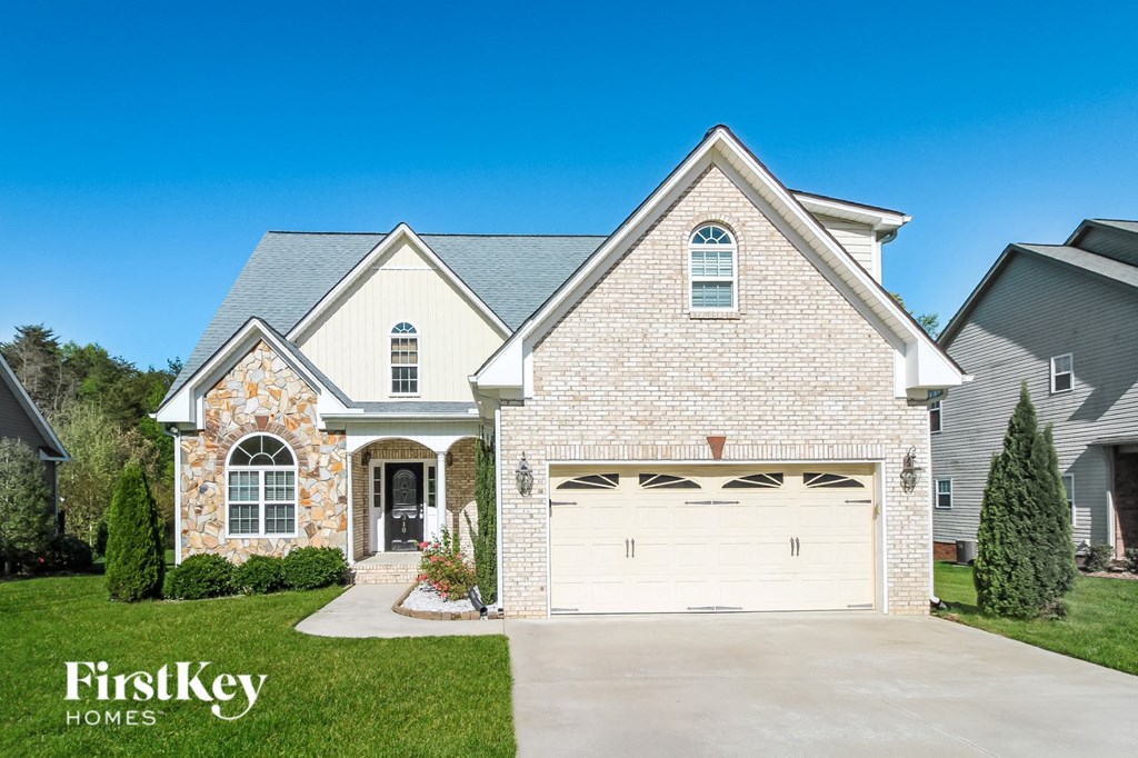 a white brick house with a white garage door in front of a house