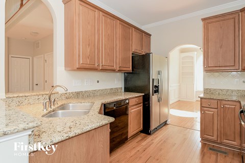 a kitchen with wooden cabinets and a sink and a refrigerator