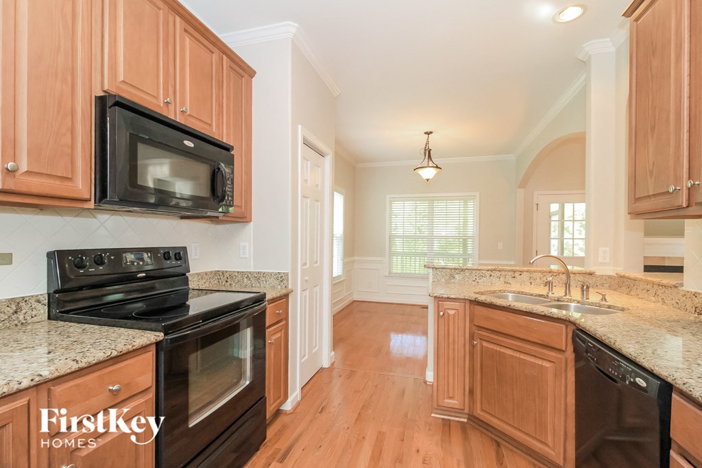 a kitchen with wooden cabinets and black appliances and granite counter tops
