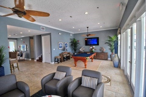 A living room with a pool table and a television.