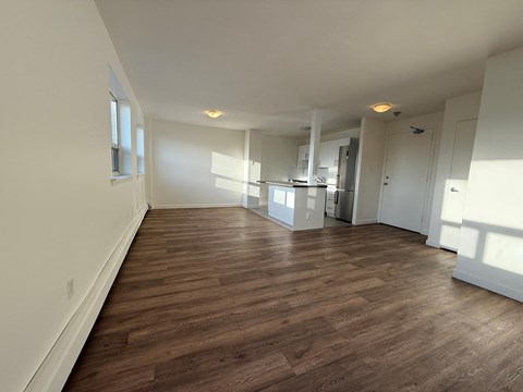 A room with wooden flooring and white walls.