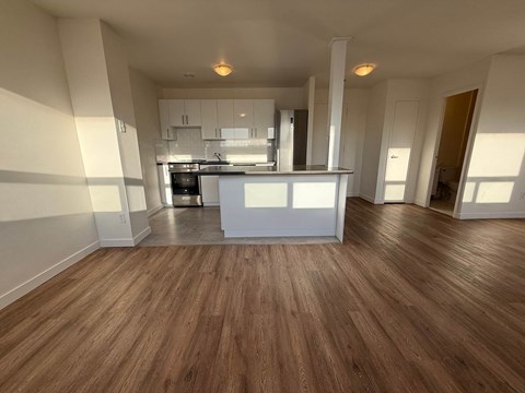 A kitchen with wooden floors and white walls.