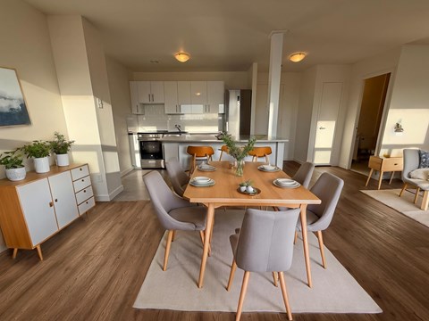 A modern dining room with a wooden table and chairs.