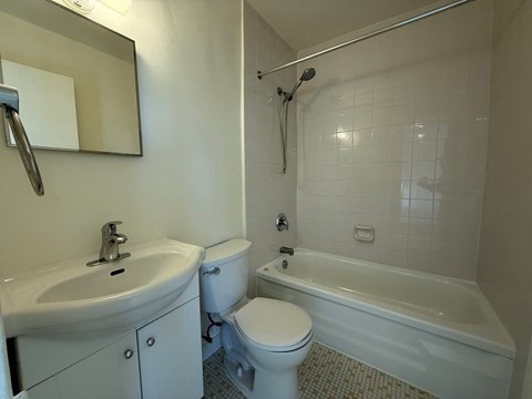A white toilet sits next to a white sink in a bathroom.