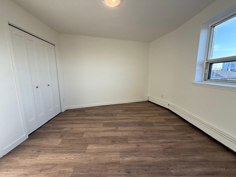 A room with wooden flooring and white walls.